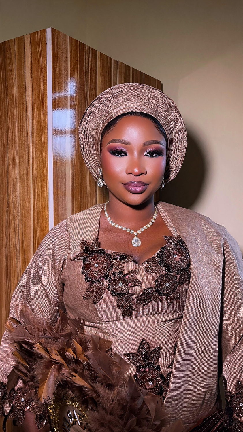 Pleated bronze metallic gele with a mauve smoky eye, satin ombre lips, crystal jewellery and a brown feather hand fan